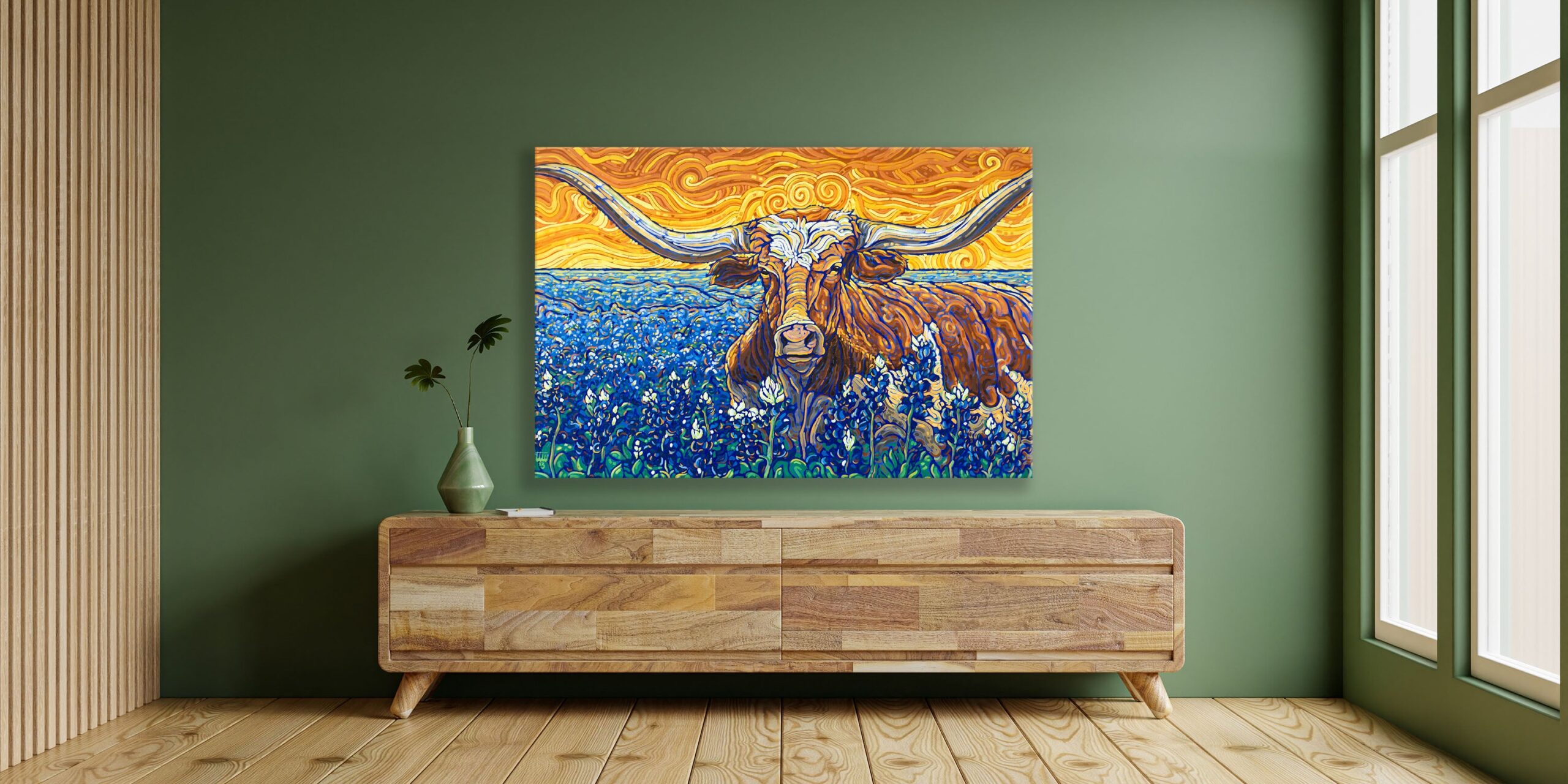 Image of commissioned painting of Texas Longhorn laying in a field of Bluebonnets hanging on the wall over a wide wooden console